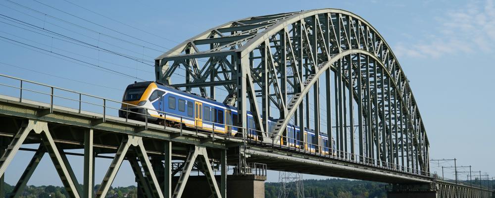 NS Sprinter-tåg på bro i Arnhem, Nederländerna Foto: Joas van der Eerden/Unsplash