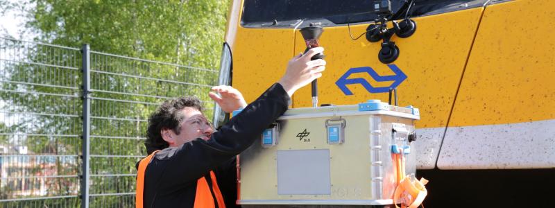 Bildtext: DLR-forskaren Paul Unterhuber kontrollerar det radiobaserade R2DATO-systemet på testbana i Amersfoort. Foto: DLR