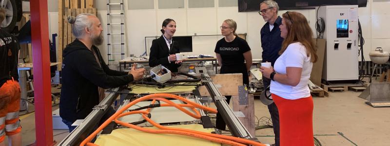 Klimat- och miljöminister Romina Pourmokhtari samtalar med Elonroads grundare Dan Zethraeus och medarbetare i fabriken i Lund. Foto: Elonroad