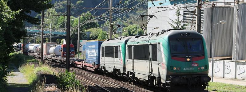Här ett lokaltåg, men från och med 1 april är även italienska Trenitalias snabbtåg Frecciarossa tillbaka på sträckan, med två dagliga tur- och returresor. Det markerar slutet på en långvarig avstängning som inte bara drabbade järnvägen, utan också påverkade motorvägen A43 och landsvägen RD1006. Bilden visar två ledande lok av typen SNCF BB 36300 drar ett Modalohr-tåg på väg mot Italien vid Saint-Michel-de-Maurienne, längs sträckan Aiton–Orbassano. Foto: Wikipedia Common, kredit: Mouliric / Eget verk.