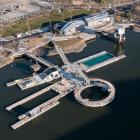 Hamnbadet i Jubileumsparken, Frihamnen 7 i Göteborg. Två naturvattenpooler och en sötvattenpool med naturlig rening, flytande ytan totalt ca 1008 m² och bassängerna sammanlagt ca 580 m². Befintliga pontoner och bassäng har återanvänts. Pontonerna är exceptionellt stora, gjutna och levererade på sänkbar pråm. Speciellt för hamnbadet är också diamantformade pontonen i mitten och den runda pontonen med hopptorn utanpå. Foto: Bluet