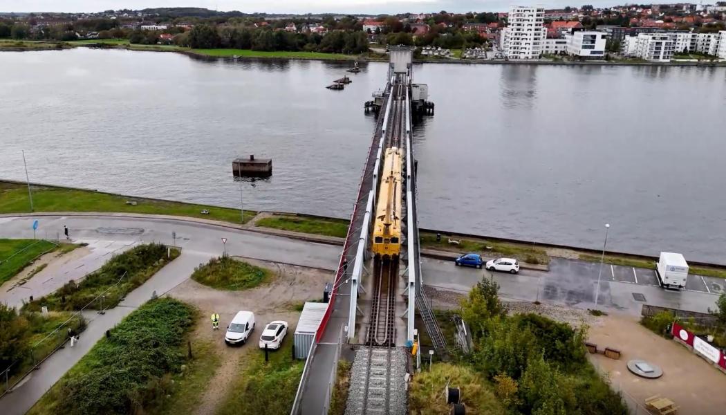Limfjordsbron i Danmark. Borrningen sker från södra sidan av fjorden och förs vidare under fjordbotten mot norr, mellan de gamla brofundamenten och den nuvarande bron. I det cirka 450 meter långa borrhålet förs ett rör in i ett stycke, varefter elkablarna dras genom röret och kopplas till kontaktledningssystemet. Foto: Banedanmark