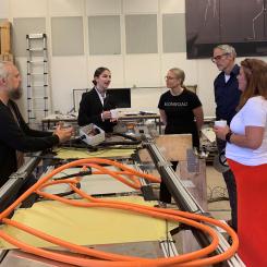 Klimat- och miljöminister Romina Pourmokhtari samtalar med Elonroads grundare Dan Zethraeus och medarbetare i fabriken i Lund. Foto: Elonroad