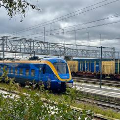 Ett persontåg från Norrtåg passerar bangården i Östersund, med godsvagnar i bakgrunden. Foto: Stina Wickenberg