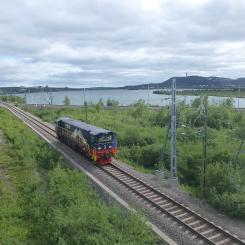 Diesellok på Malmbanan vid spårtriangeln Peuravaara driftplats nära Kiruna. I bakgrunden syns sjön Luossajärvi. Foto: Leif Jørgensen/Wikimedia Commons/https://commons.wikimedia.org/wiki/File:Peuravaara_driftplats_05.JPG