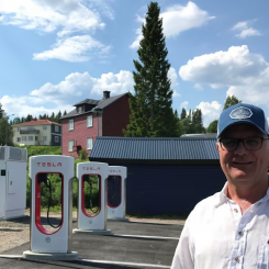 Sten Danielsson framför Teslas tre superchargers som numera står i Gäddede. Foto: Biofuel Region