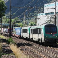Här ett lokaltåg, men från och med 1 april är även italienska Trenitalias snabbtåg Frecciarossa tillbaka på sträckan, med två dagliga tur- och returresor. Det markerar slutet på en långvarig avstängning som inte bara drabbade järnvägen, utan också påverkade motorvägen A43 och landsvägen RD1006. Bilden visar två ledande lok av typen SNCF BB 36300 drar ett Modalohr-tåg på väg mot Italien vid Saint-Michel-de-Maurienne, längs sträckan Aiton–Orbassano. Foto: Wikipedia Common, kredit: Mouliric / Eget verk.